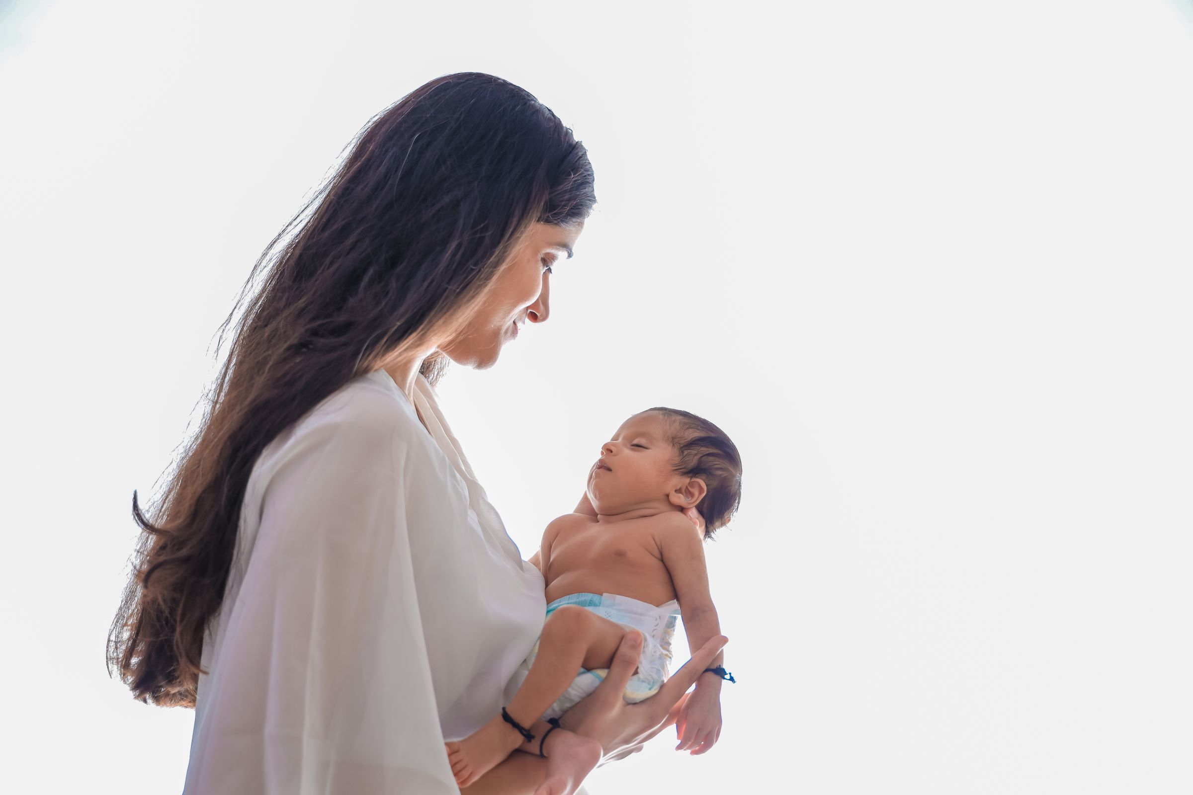 Mother gently holding her sleeping newborn